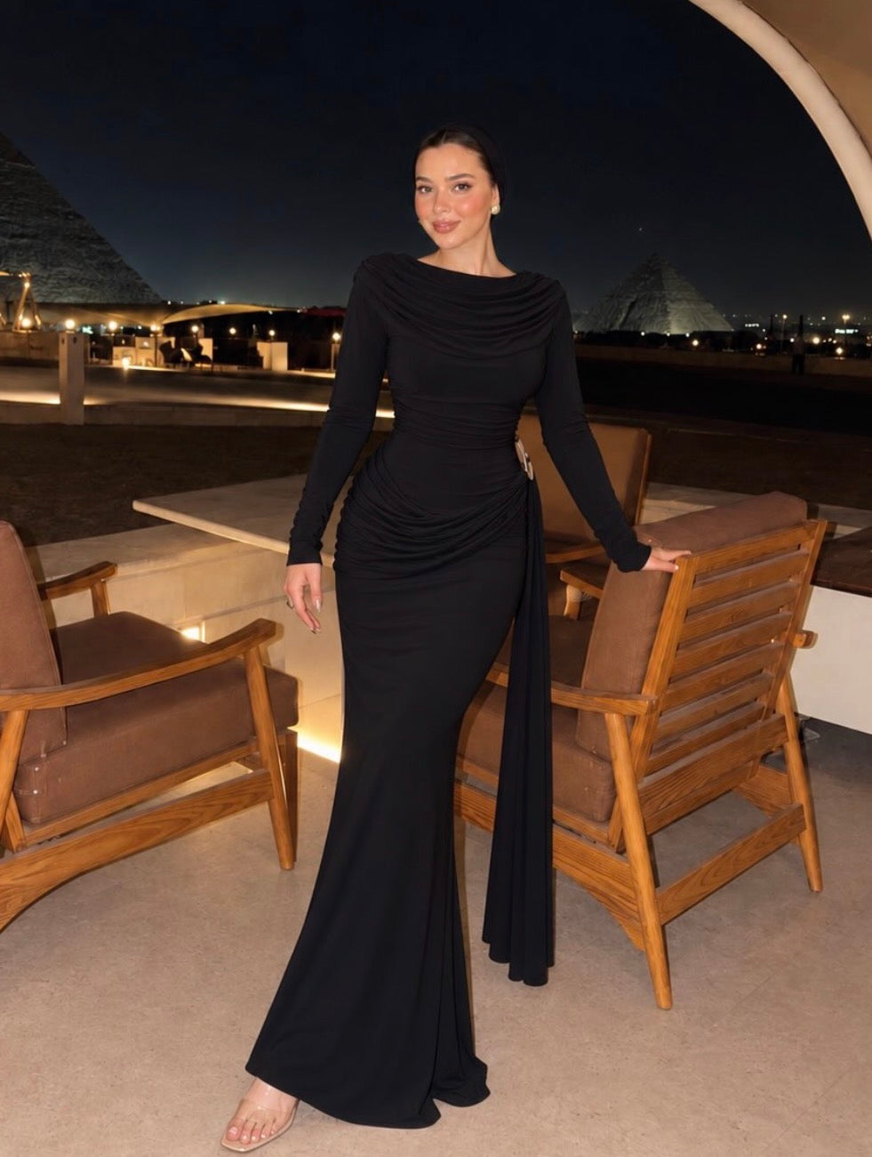 Black long-sleeved maxi dress with gathered draping and a long side sash